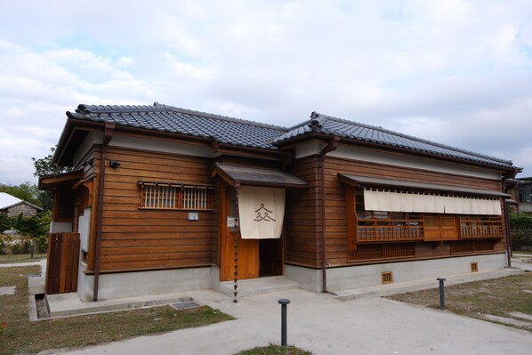 A traditional wooden building with a tiled roof, a wooden door, and a small porch. - Machiya Posong (Taitung)