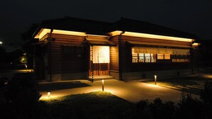 Un edificio de madera tradicional con una entrada bien iluminada y un pequeño jardín.
