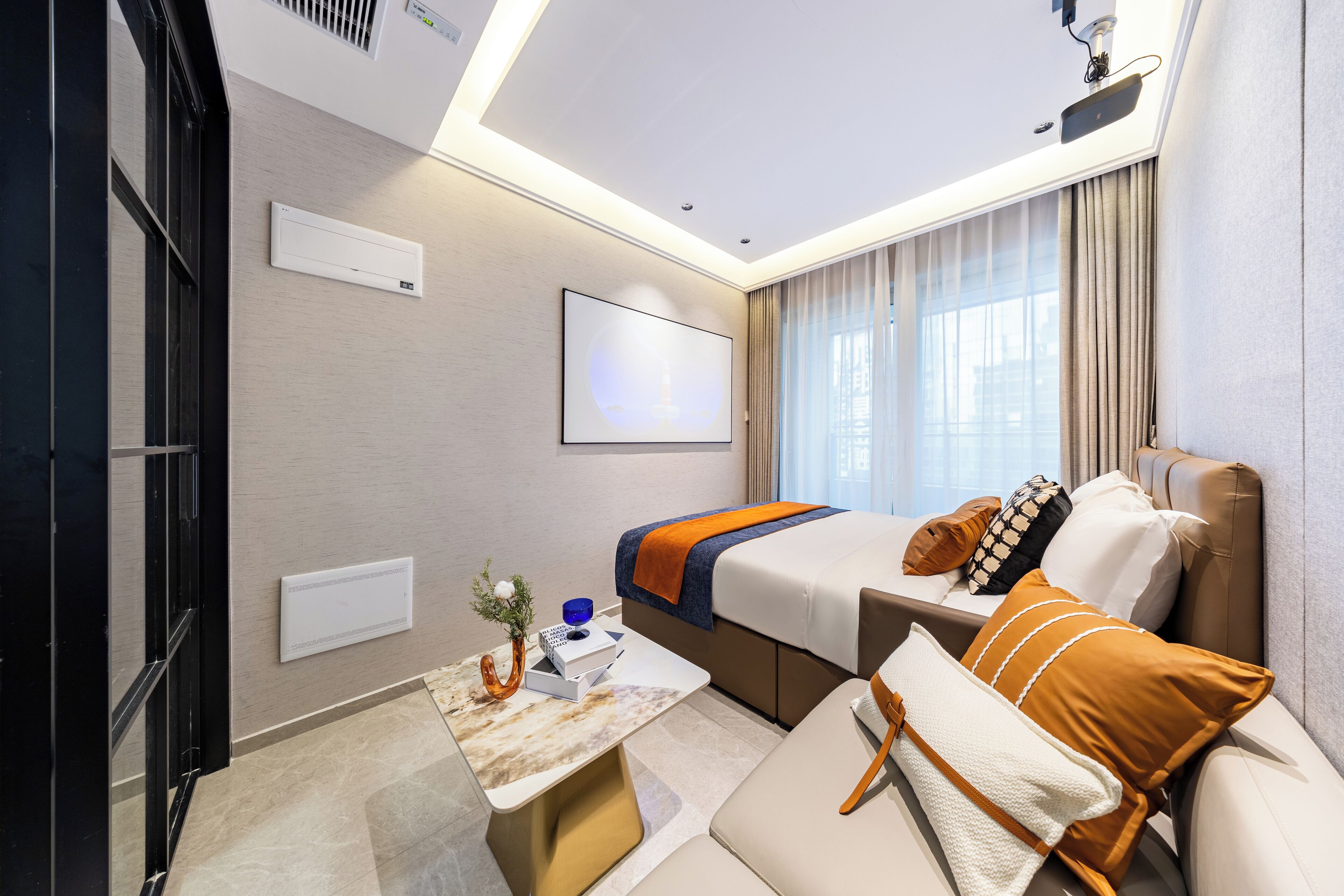 Ein Hotelzimmer mit Bett, einer Couch, einem kleinen Tisch und einem Fernseher.