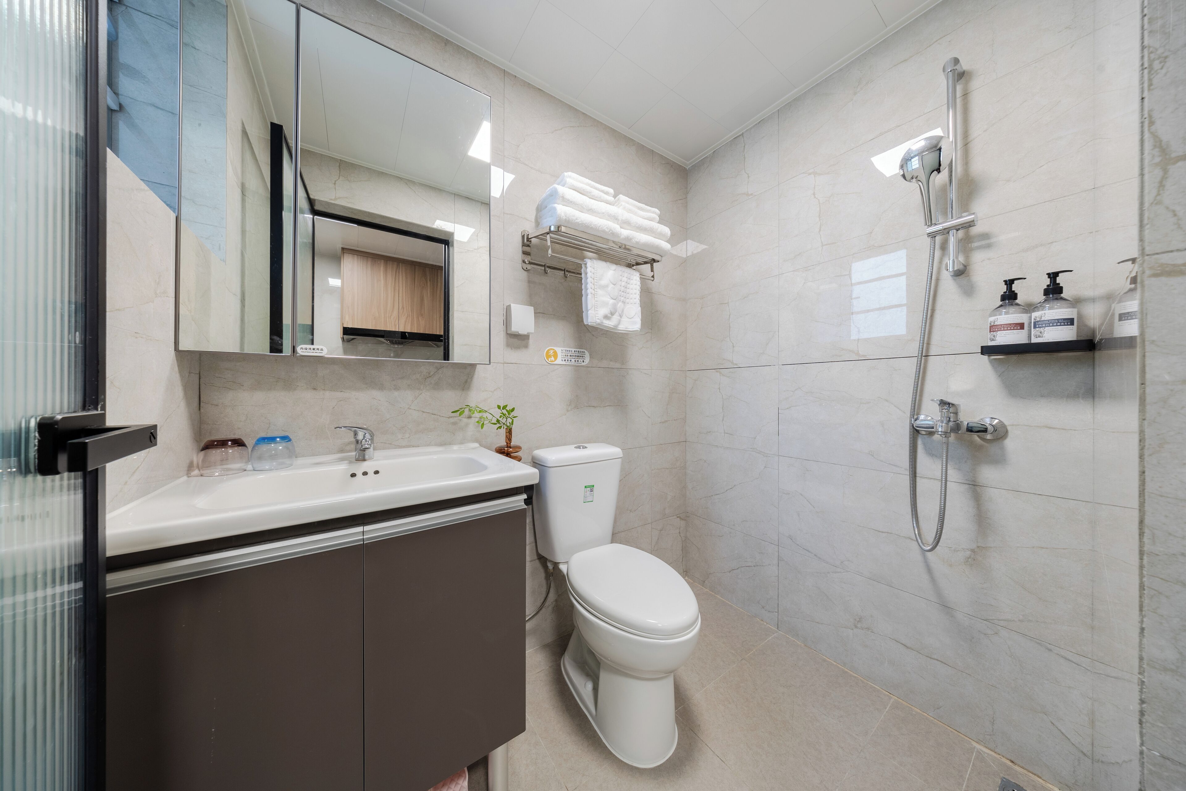 A modern bathroom with a toilet, sink, and shower.