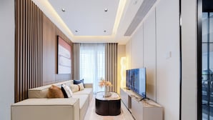 A modern living room with a sofa, a coffee table, and a flat-screen TV. - Gangxiahui Hotel Apartments (Shenzhen)