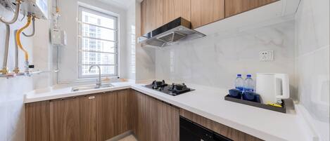 Una cocina moderna con armarios de madera, lavavajillas integrado, estufa y una ventana que proporciona luz natural.