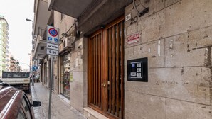 Straßenansicht mit einem Gebäude, das eine große Holztür, ein Nicht-Parken-Schild und ein Schild mit einem Abstand von 20 Metern zeigt.