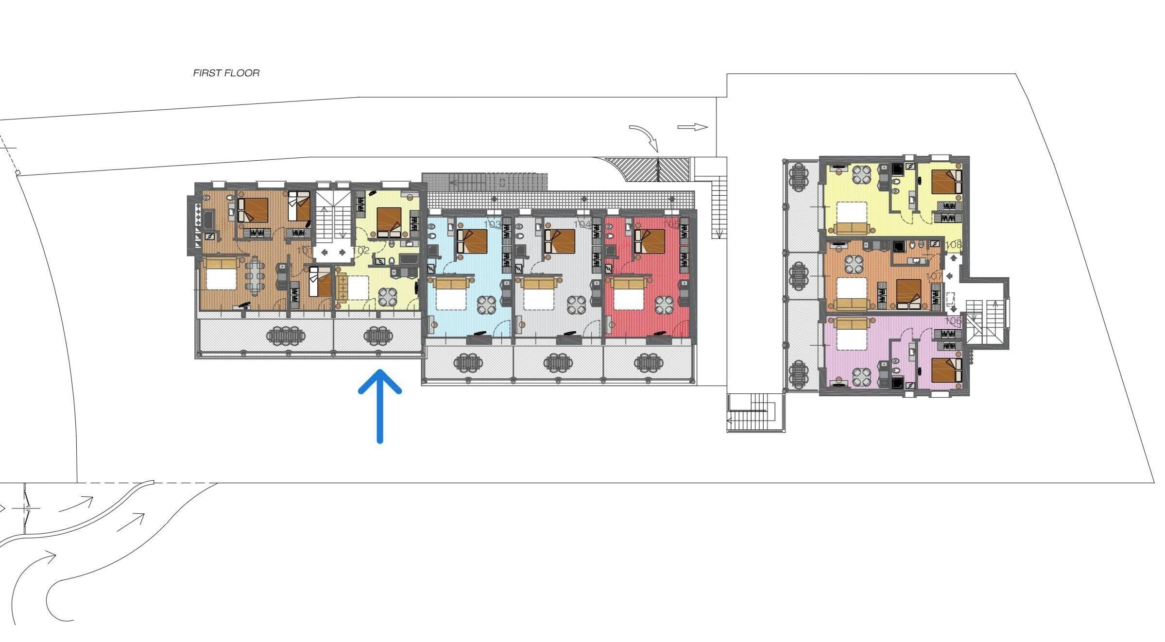 A floor plan of a hotel with multiple rooms, a common area, and a staircase.