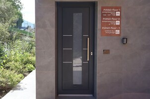Una puerta moderna con un cartel que indica la ubicación del piso del piano, apartamentos y garaje.