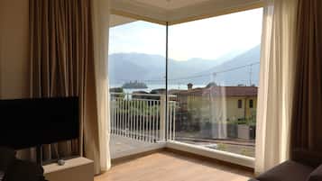 Departamento Deluxe, balcón, vista al lago | Área de sala de estar | Televisión de pantalla plana