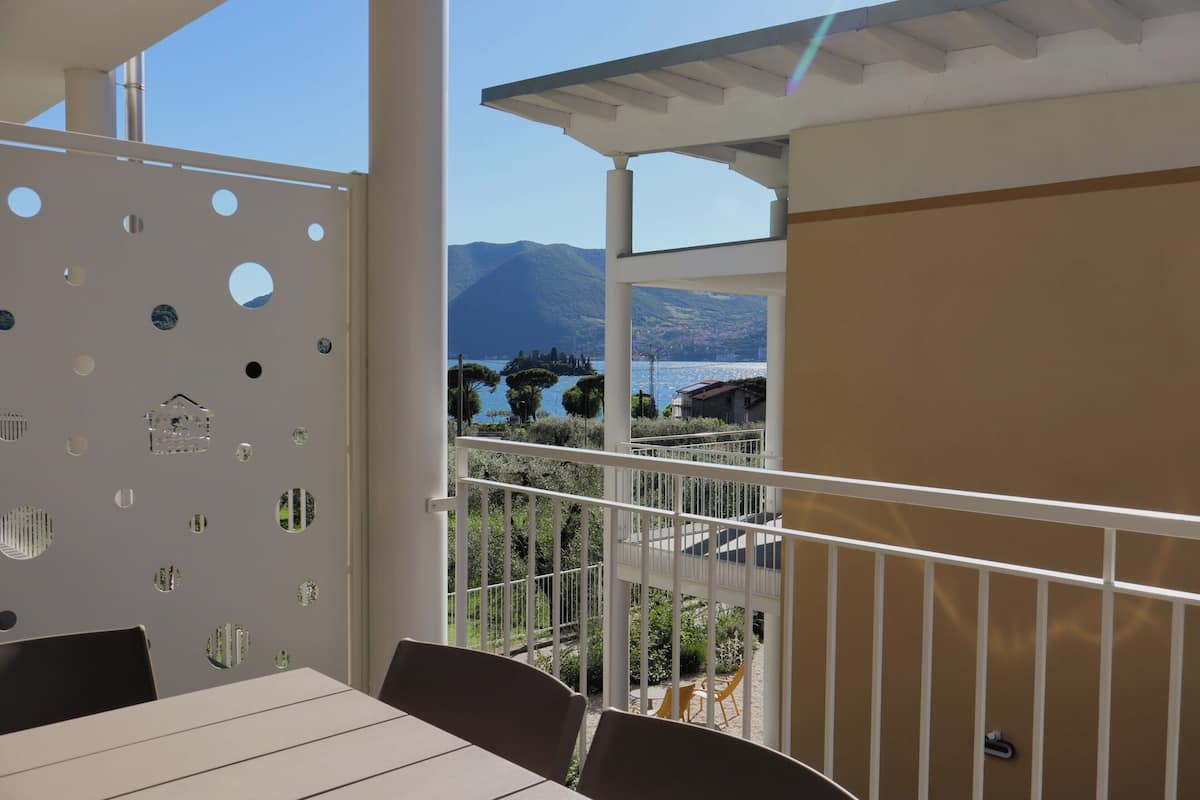 Uma varanda com vista para montanhas e um lago.
