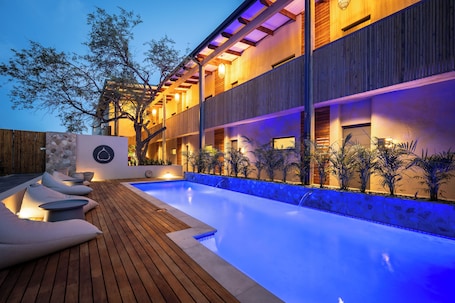 Una piscina al aire libre, sillones reclinables de piscina