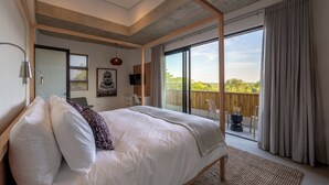Quarto com uma cama grande, televisão, ventoinha no teto e varanda com vista.