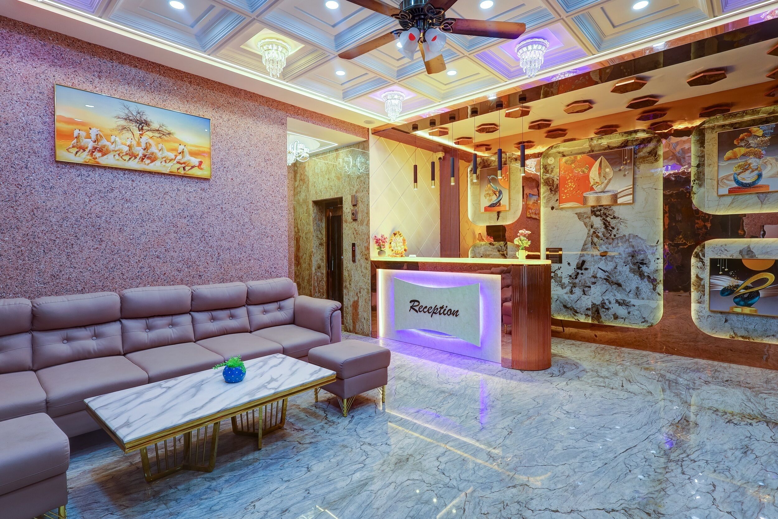 A reception area with a marble floor, a reception desk, a cushioned seating area, and a ceiling fan.