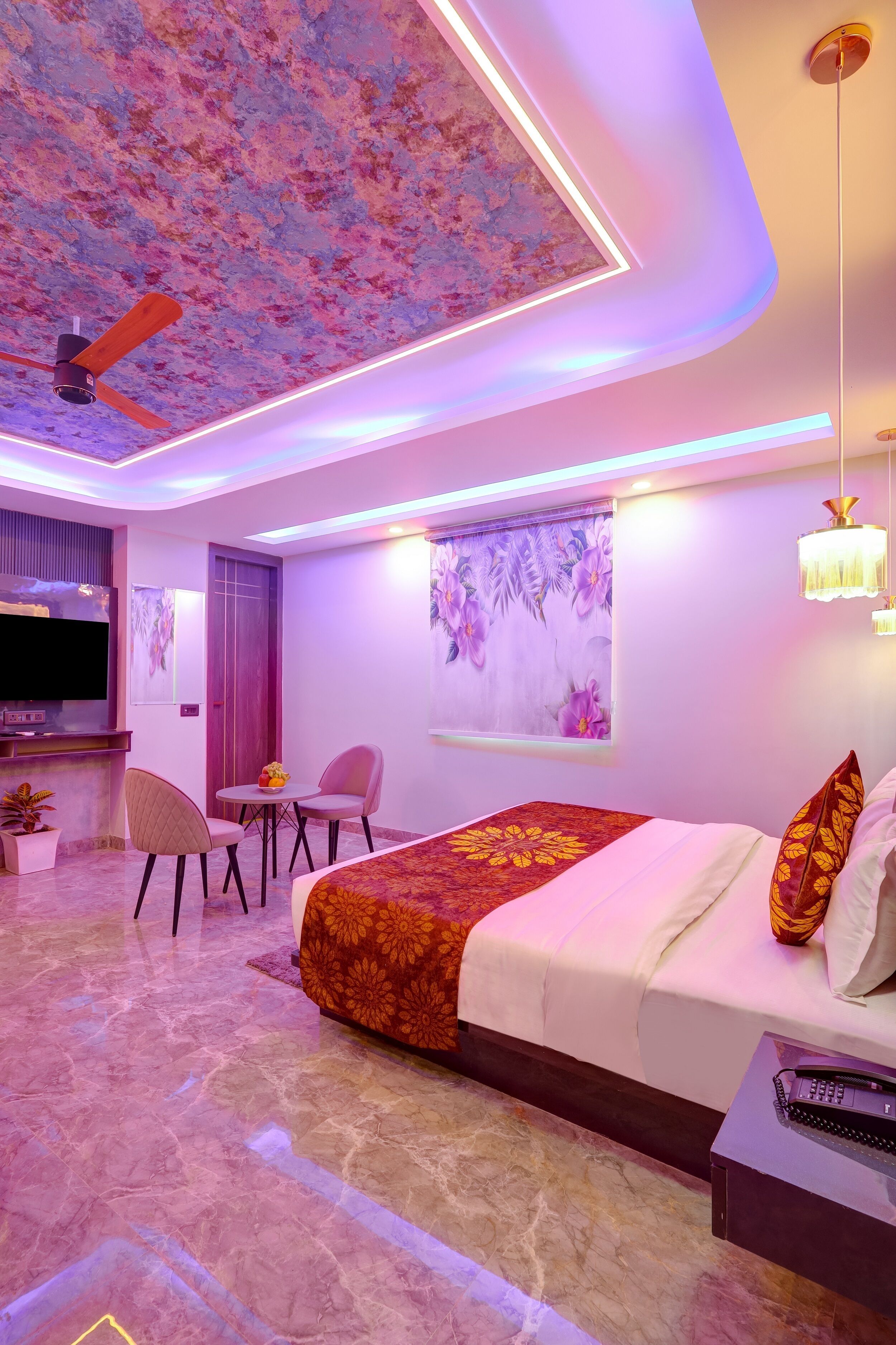 A modern hotel room with a large bed, a desk, and a television.