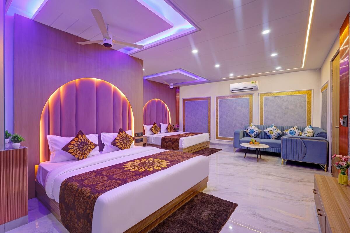 Een moderne hotelkamer met een groot bed, een slaapbank en een klein tafeltje.