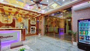 A reception area with a marble floor, a ceiling fan, and a VOLTAS refrigerator.