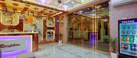 A reception area with a marble floor, a ceiling fan, and a VOLTAS refrigerator.