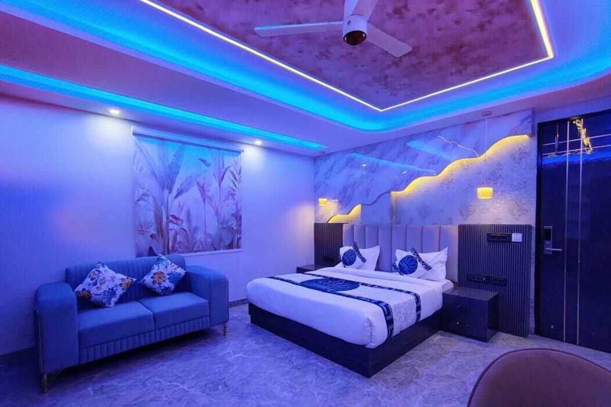 Een moderne slaapkamer met een bed, een slaapbank en een stoel.