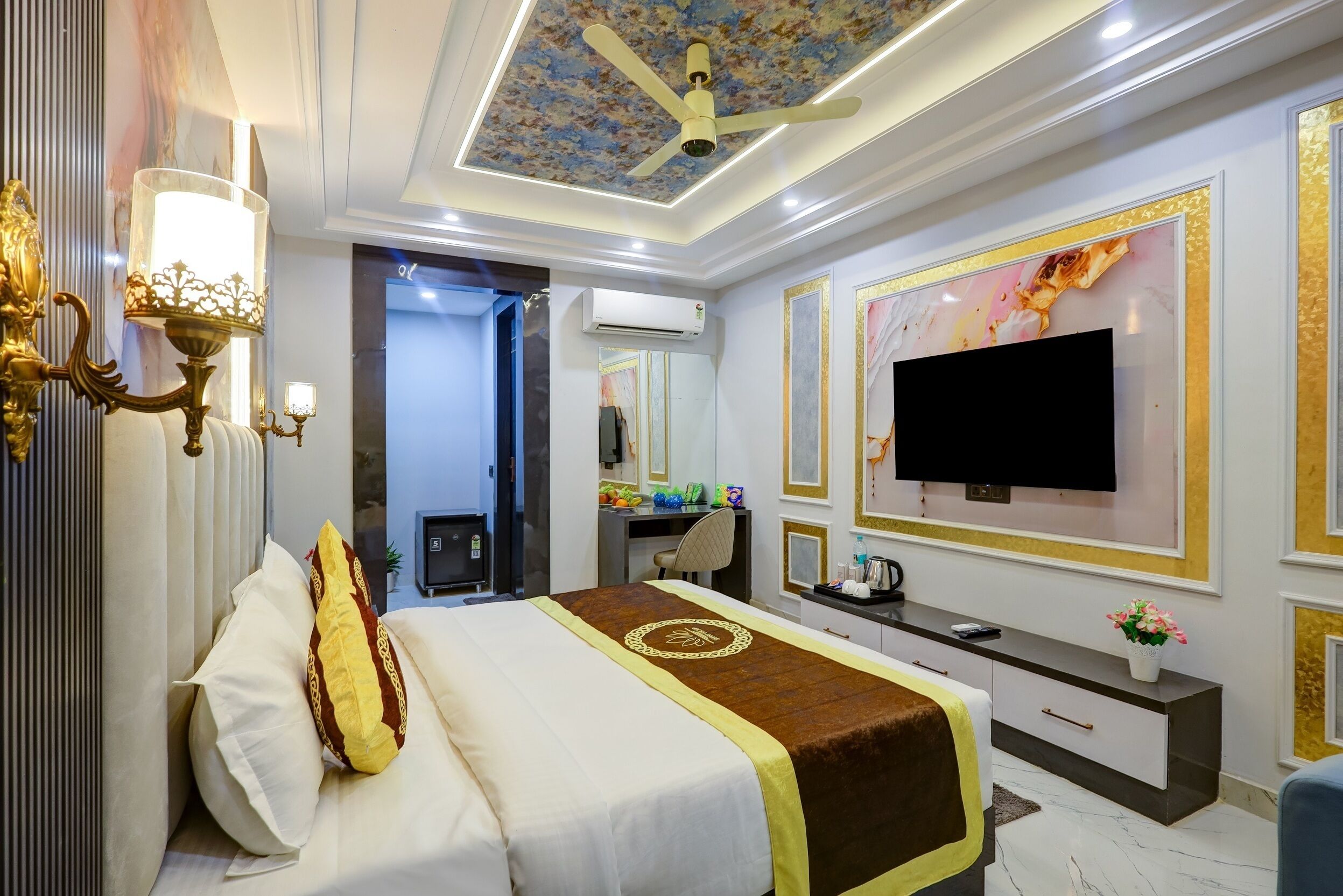 A hotel room with a bed, a desk, a TV, and a ceiling fan.