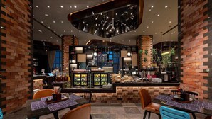 A restaurant interior with brick walls, a bar area, and seating with tables and chairs. - Ethos Hotel Wuhan Riverside (Wuhan)