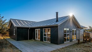 A modern house with a sloped roof, large windows, and a deck. - "Kaapo" - 300m from the sea by Interhome (Løkken)