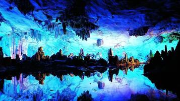 An ice cave with reflective surfaces and stalactites.