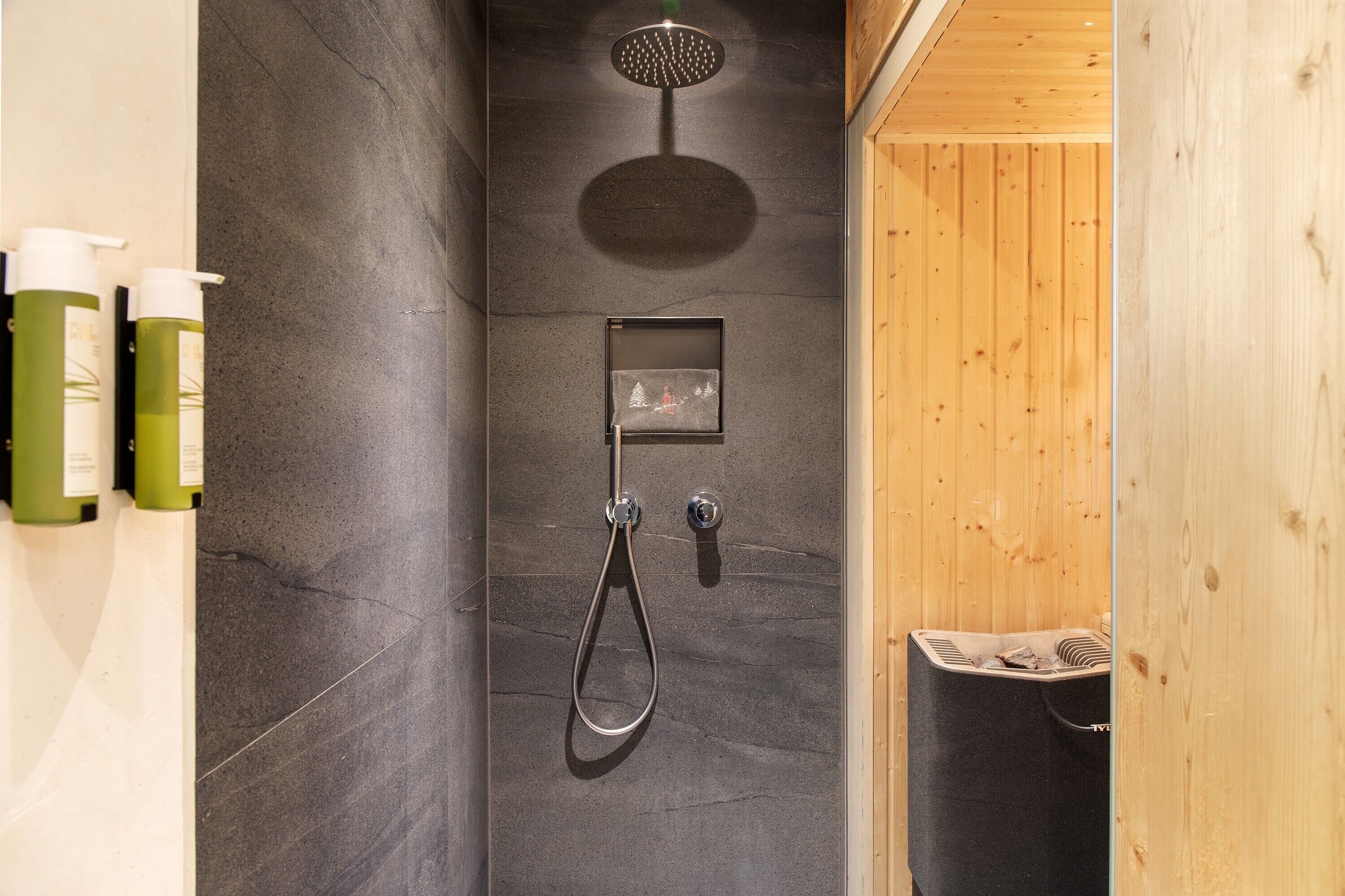 Eine Dusche mit Duschbrause, Wandarmatur und einem kleinen Bild in einem Rahmen.