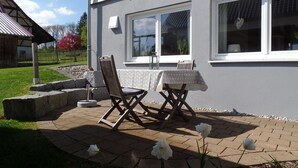A patio with outdoor furniture, a table, and chairs.