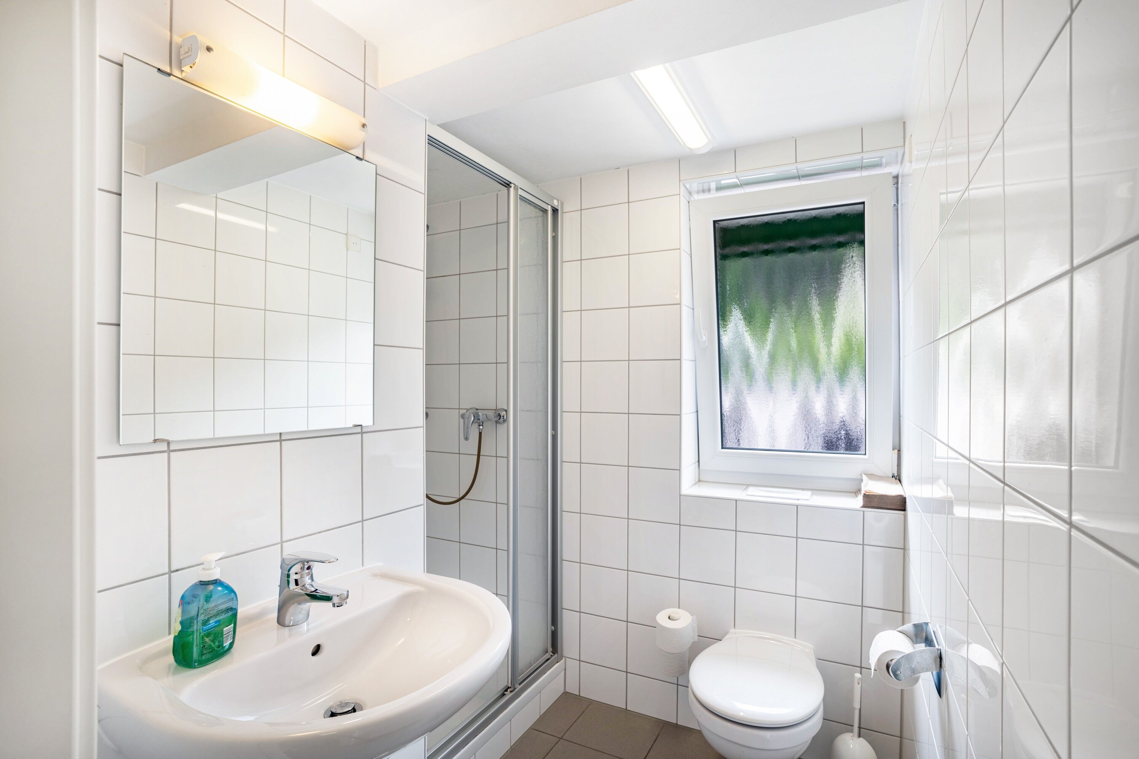 Ein modernes Badezimmer mit Waschbecken, Toilette und Dusche.