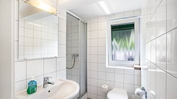 A modern bathroom with a sink, toilet, and shower.