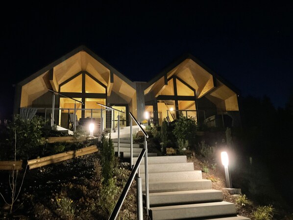 A modern building with a staircase leading to a well-lit entrance.