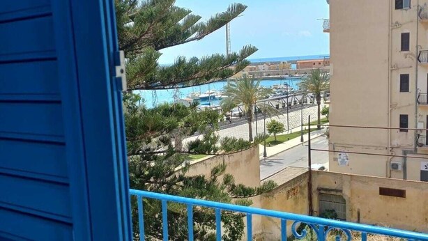 A balcony with a view of a marina, buildings, and a clear sky. - Vacation home Perla Marina (Porto Empedocle)