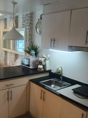 Eine moderne Küche mit Steinwand, einer Uhr, einem Wasserkocher und einem Toaster.