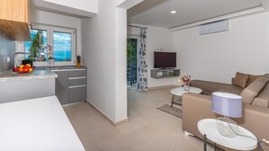 A modern apartment with a kitchen, dining area, and living room. - Apartman Helena (Crikvenica)