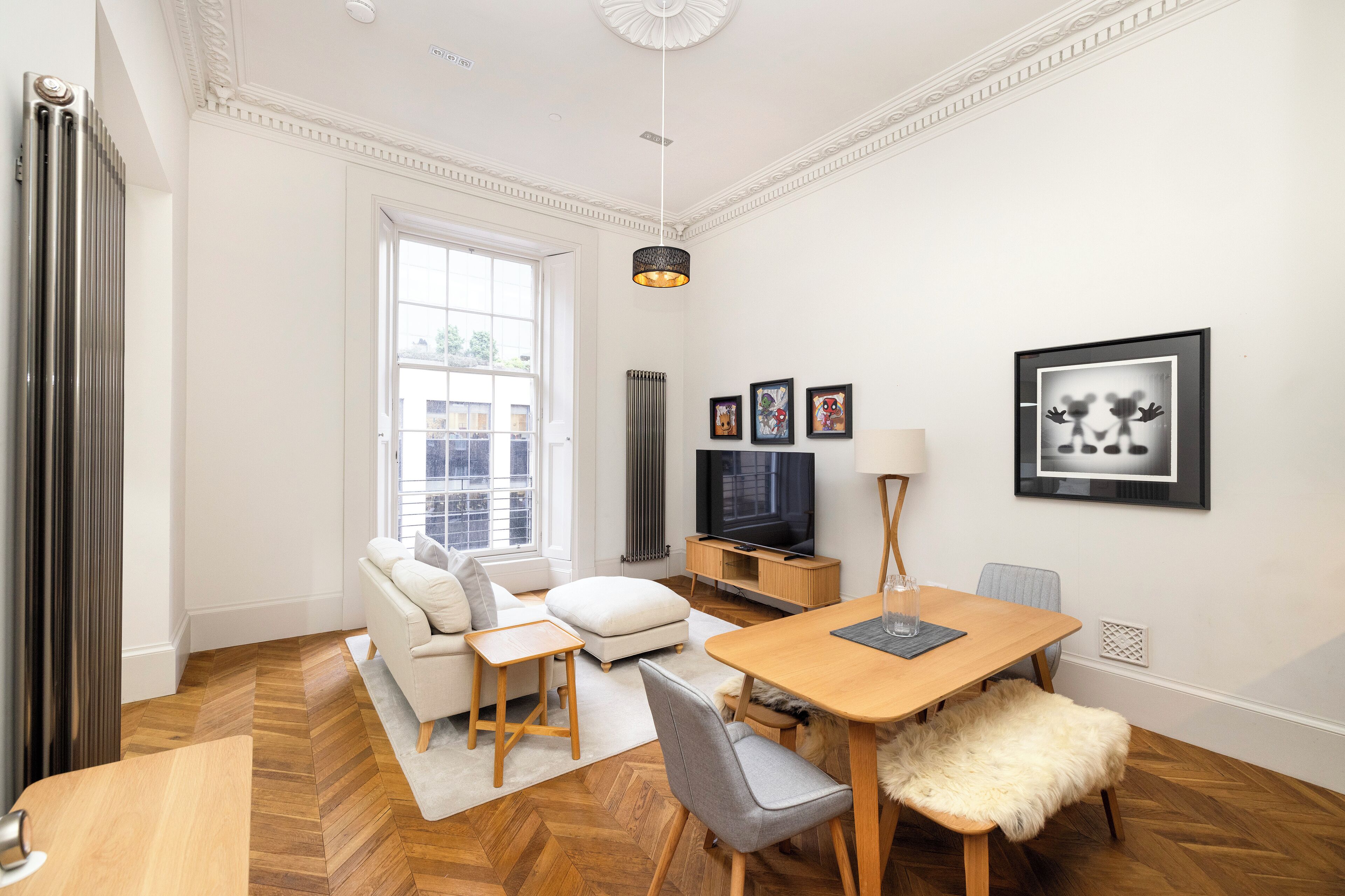 A modern living room with a sofa, a dining table, and a TV.