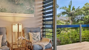 A balcony with a view of greenery and a wooden deck.