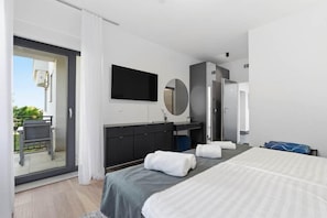 Une chambre d’hôtel moderne équipée d’un lit, d’un bureau, d’un miroir et d’une télévision.