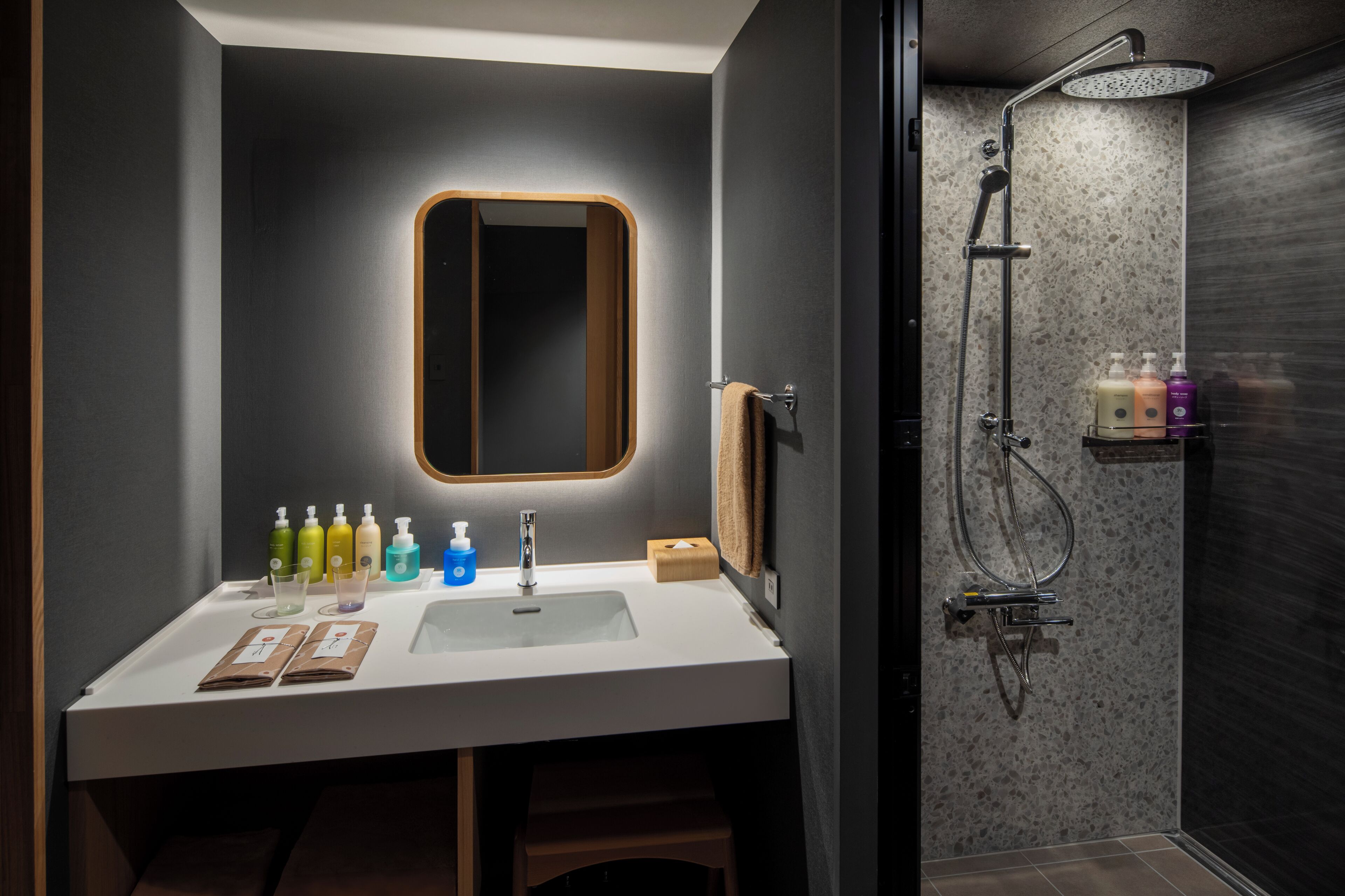 A modern bathroom with a white sink, a mirror, and a shower.