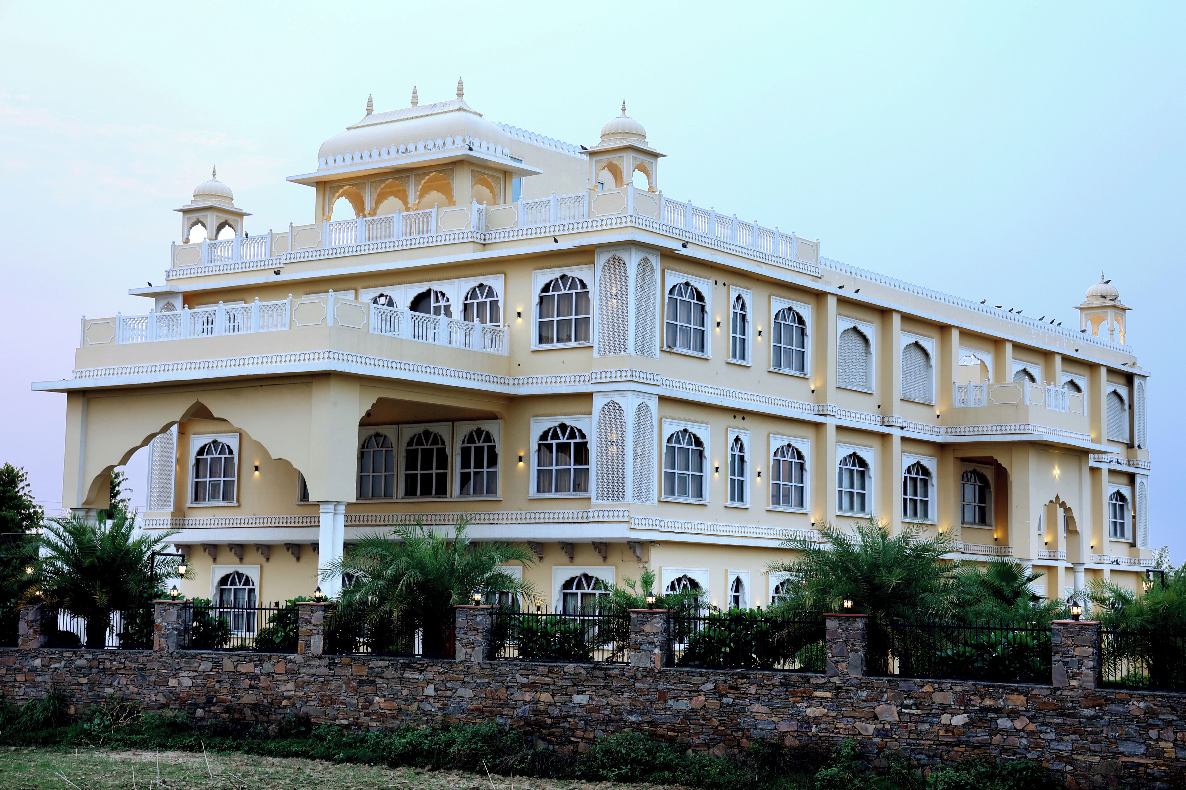 A large, multi-story building with a traditional architectural style, featuring multiple balconies and arched windows.