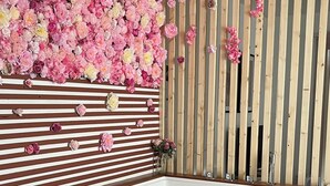 A modern bathroom with a large bathtub, wooden slats on the wall, and a floral arrangement above the bathtub. - Jacuzzi balnéo center of bordeaux (Bordeaux)
