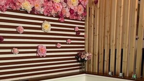 A spa area with a large bathtub, wooden panel wall, and a floral arrangement above the tub. - Jacuzzi balnéo center of bordeaux (Bordeaux)