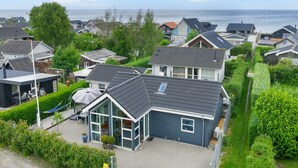 Un barrio residencial con casas, un camino de entrada pavimentado y vista al mar.