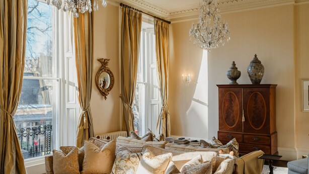 Ein geräumiges Wohnzimmer mit einer großen Couch, einem Holzschrank und einem Chandelier.