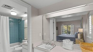 Een badkamer met een bad, toilet, wastafel en een grote spiegel.