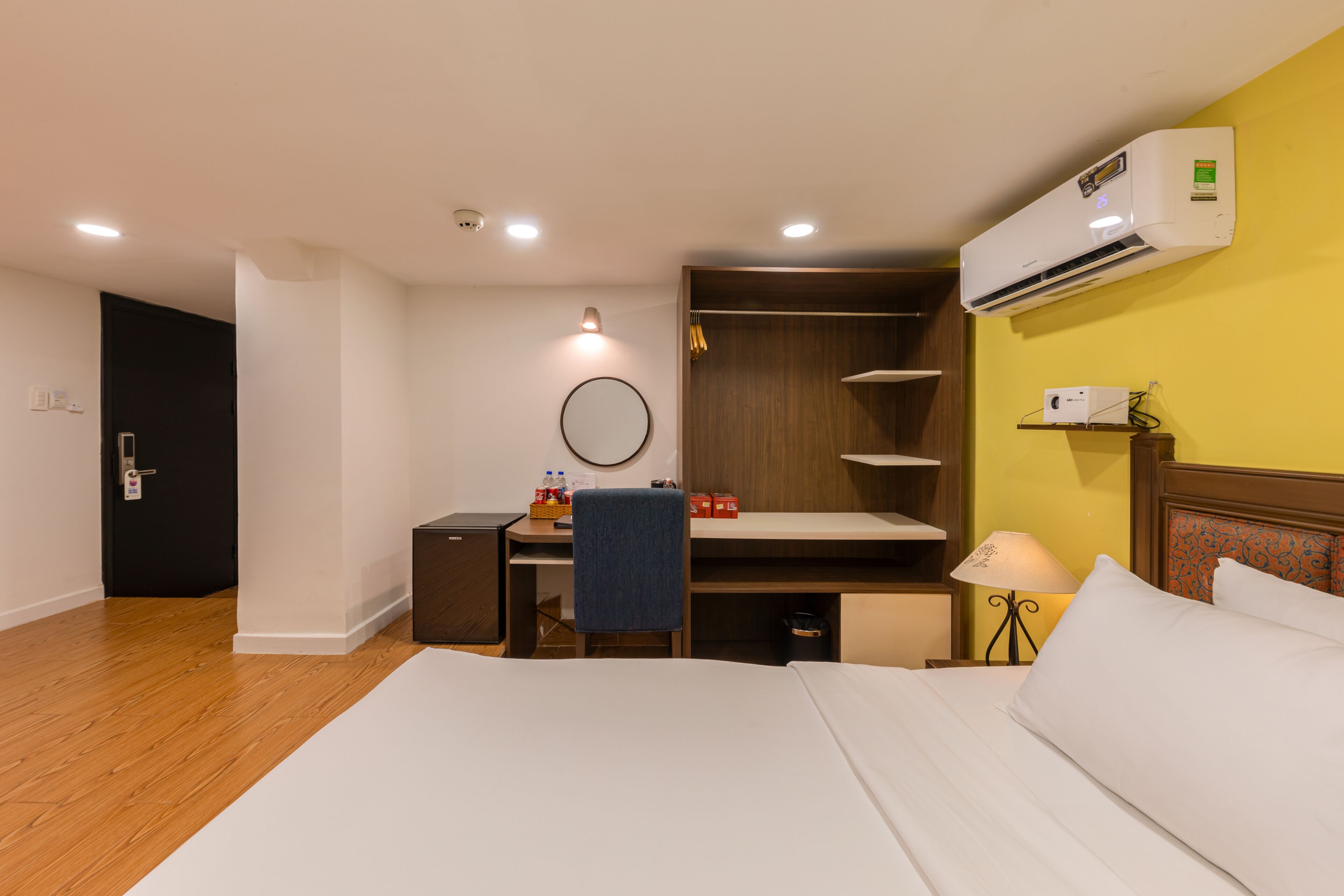 Une chambre d’hôtel équipée d’un lit, d’un bureau, d’une chaise, d’une armoire et d’un appareil de climatisation.