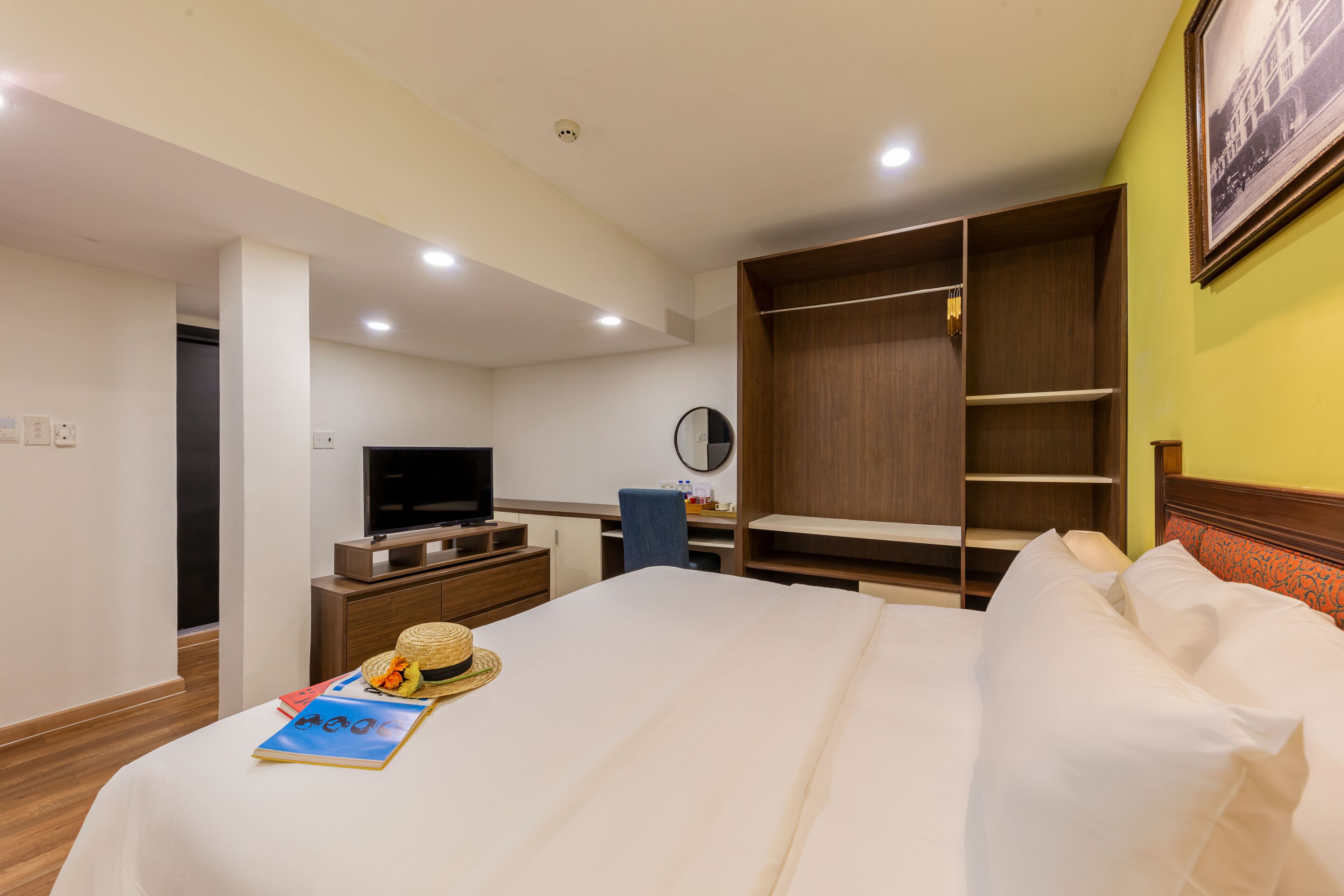 Una habitación de hotel con cama, televisión, armario y escritorio con silla.
