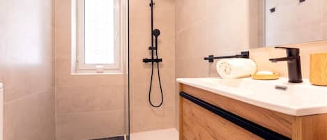 A modern bathroom with a shower, toilet, and vanity.