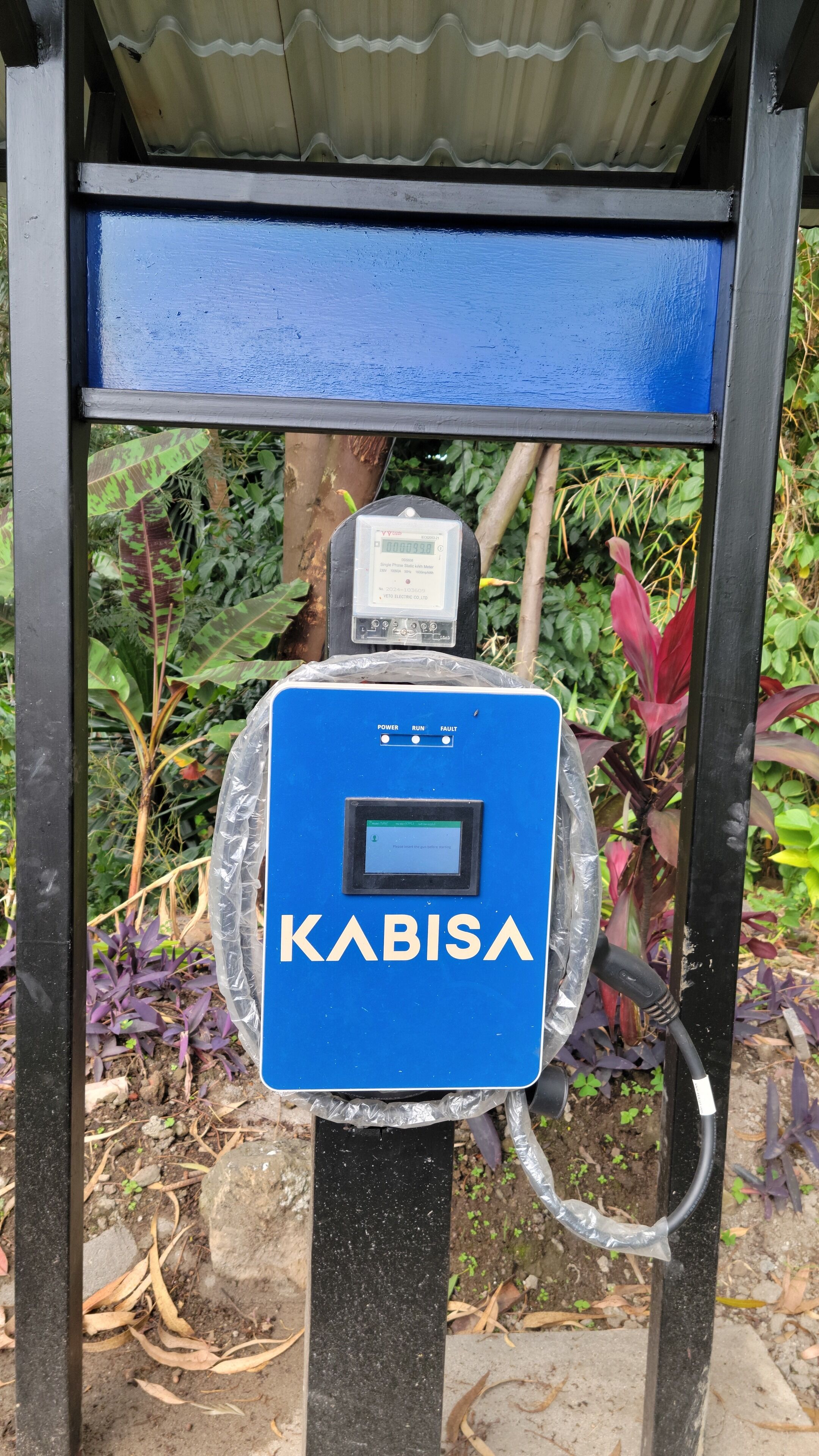 A blue electric vehicle charging station branded 'KABISA' with a digital display and control buttons.