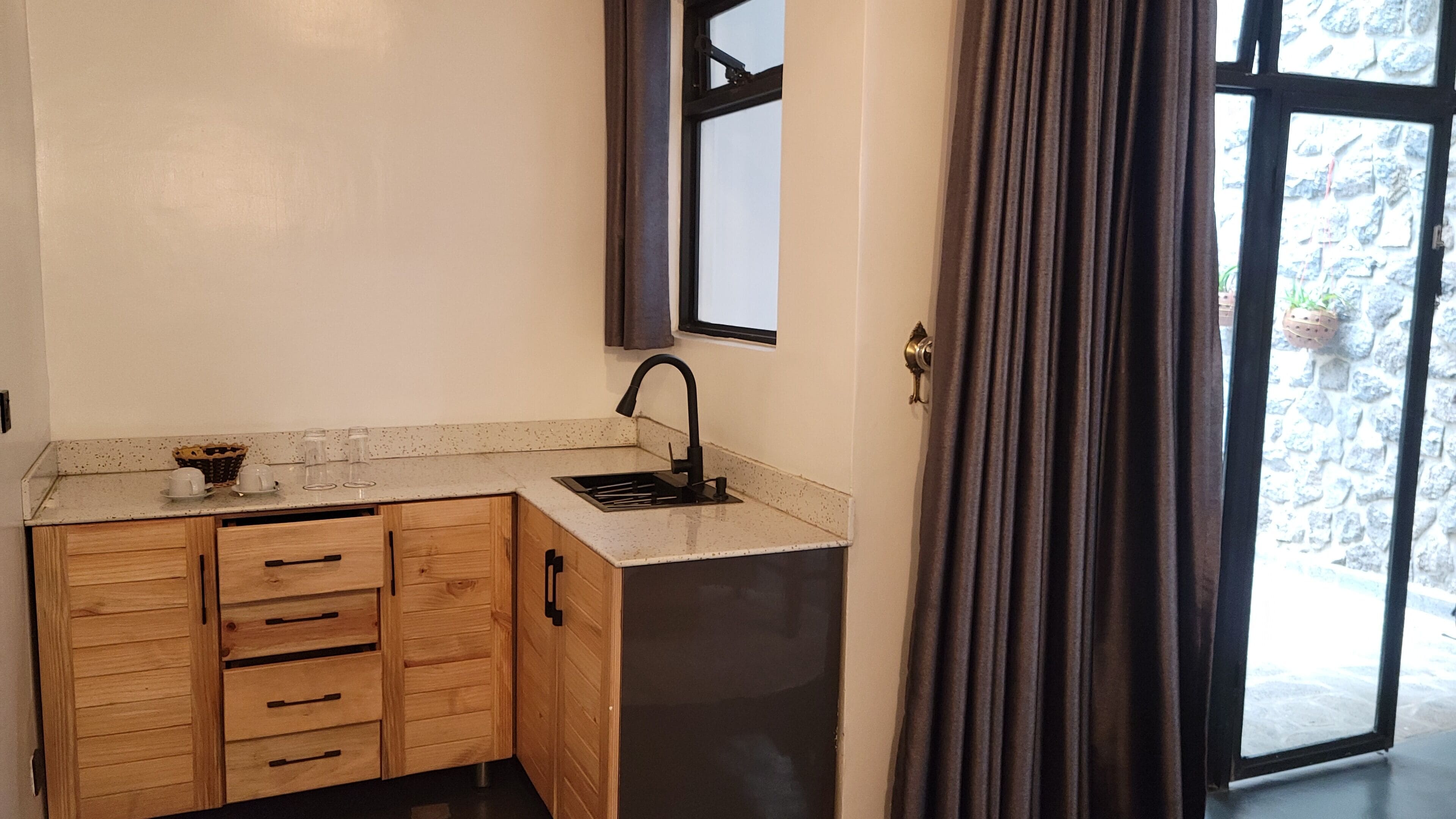 A compact kitchen with wooden cabinets, a sink, and a window.