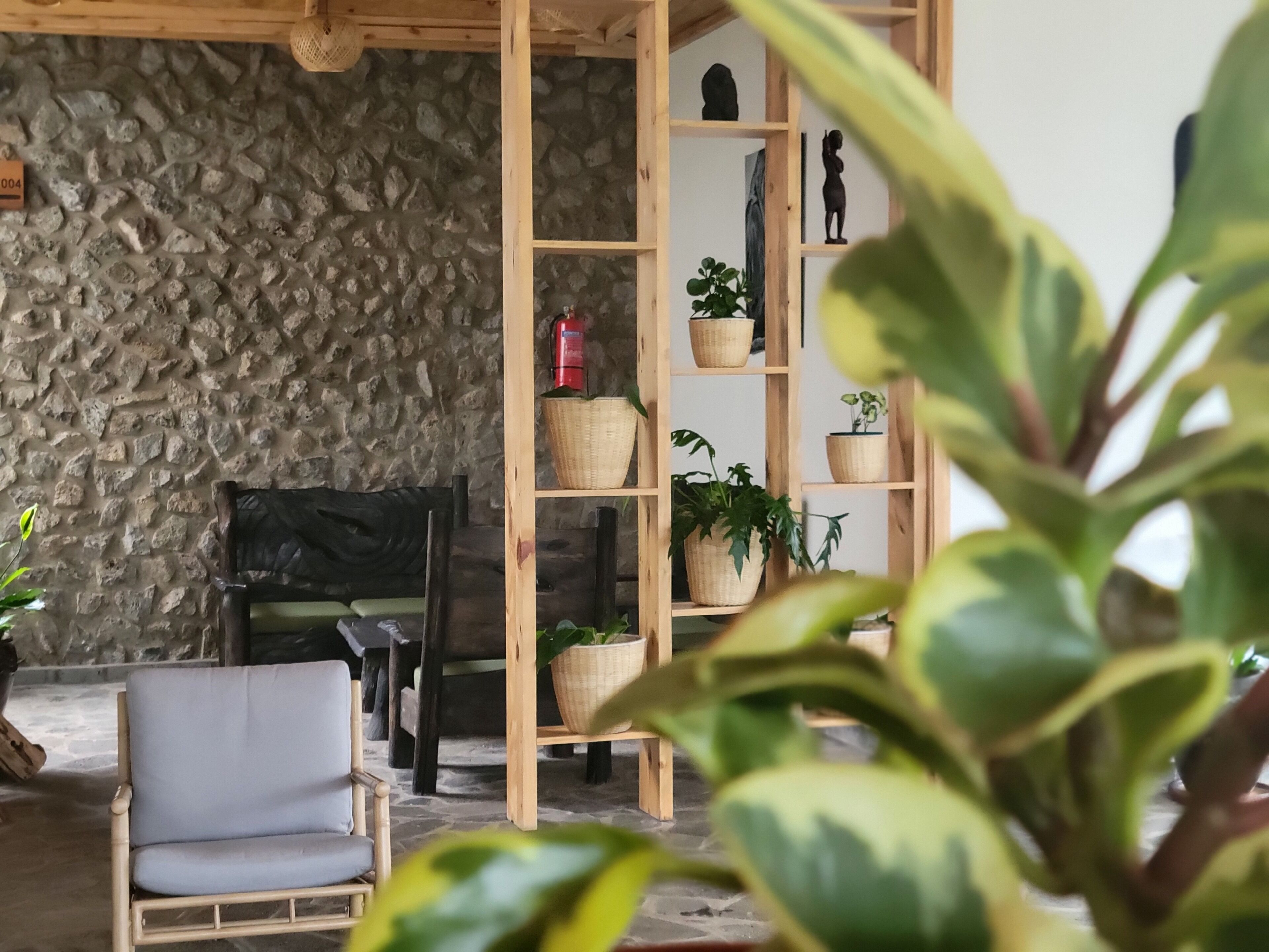 A cozy living room with a stone wall, a wooden bookshelf, and a comfortable chair.