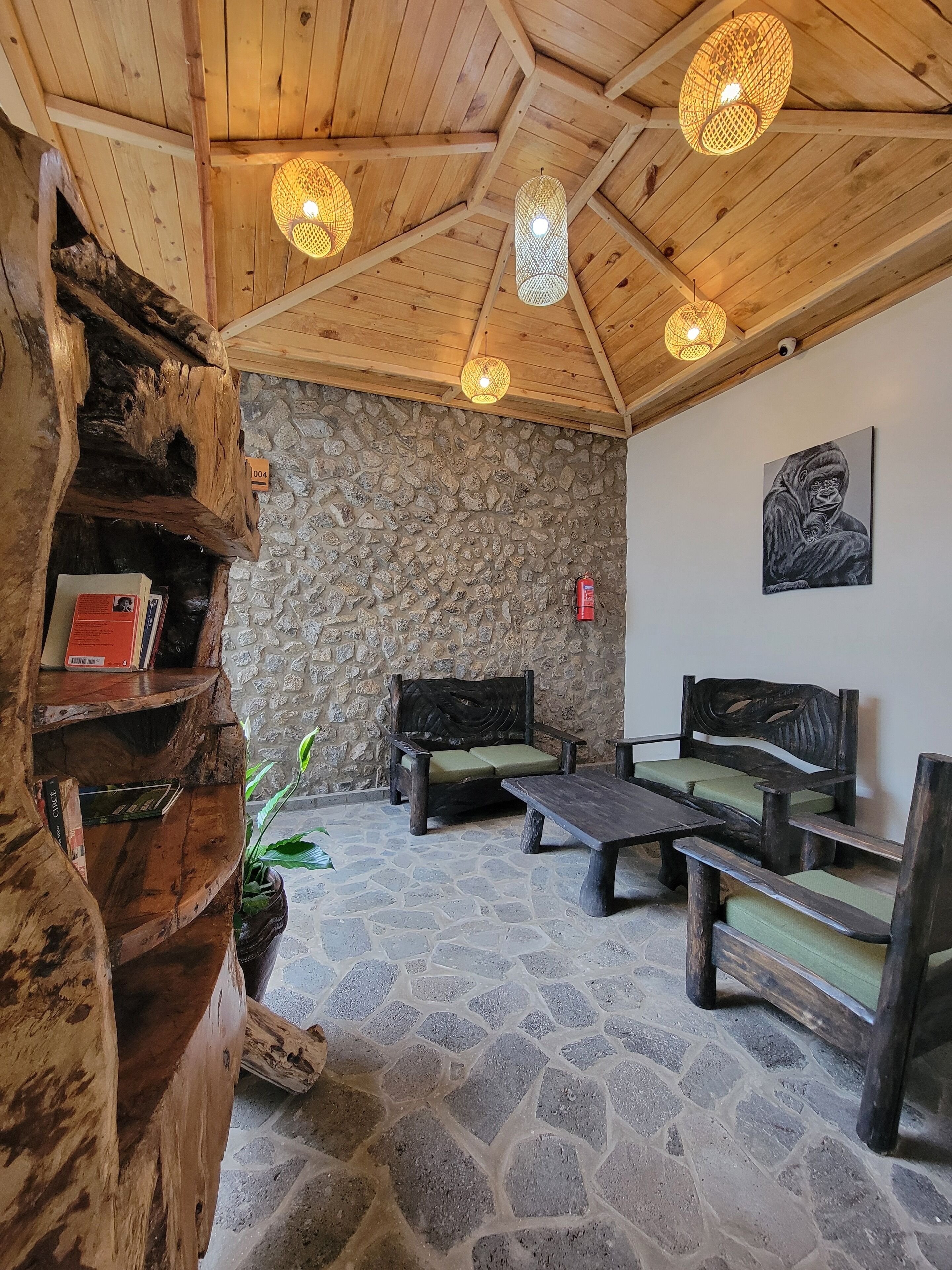A rustic interior with wooden beams, stone walls, and a wooden bench with cushions.