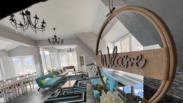 A modern living room with a sofa, coffee table, and a 'Welcome' sign. - Premont Guesthouse Bran (Bran)