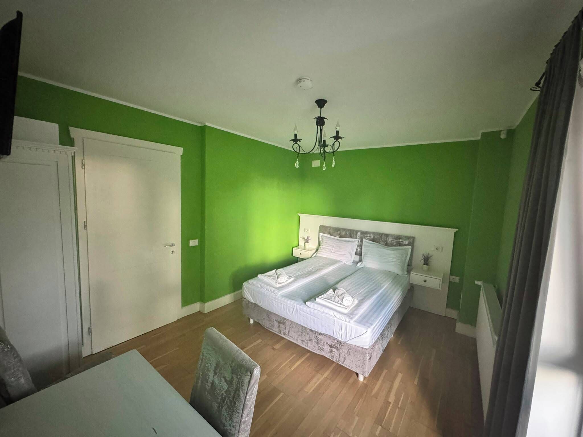Une pièce comprenant un lit, une chaise, une table et un lustre.